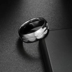 Modern black geometric ring with silver circle patterns on a black jewelry box
