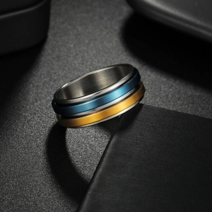Detalle de un anillo giratorio de tres capas de acero inoxidable con acabado oro y azul