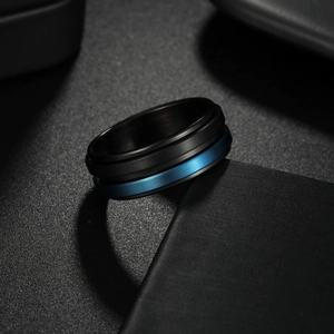 Detalle de anillo de acero negro mate con banda giratoria azul en el centro