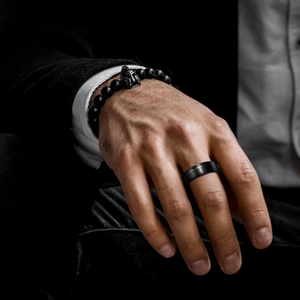 Matte black stainless steel ring and beaded warrior bracelet on male model wrist