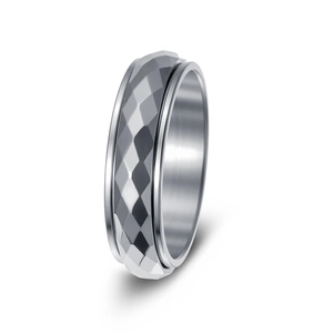 Macro detail of silver titanium spinner ring featuring a geometric rhombic faceted surface