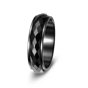 Detail of black geometric rhombic faceted spinner ring with brushed interior texture