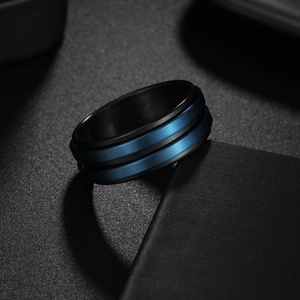 Detalle del anillo giratorio de descompresión en metal cepillado azul y negro mate