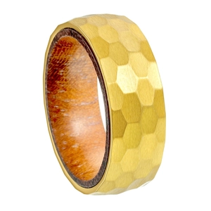 Gros plan sur une bague 8mm en titane doré avec martelage alvéolé et insert en bois