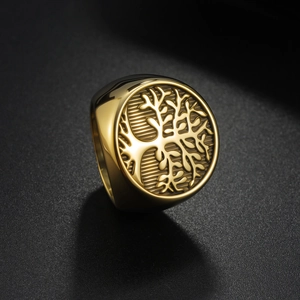 Macro shot of polished gold signet ring featuring a detailed Tree of Life relief engraving