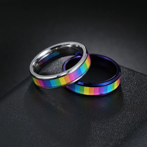 Neutral titanium steel rainbow rings in silver and blue finishes on leather background