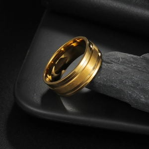 Detail of gold titanium ring featuring a brushed finish and polished center groove