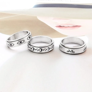 Three-piece stainless steel spinner ring set featuring evil eye, star moon, and cat patterns