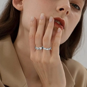 Silver celestial ring set with moon patterns on a model's hand in professional attire