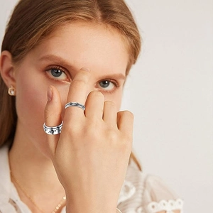 Rotating stainless steel star and moon ring set on a female model with a polished finish
