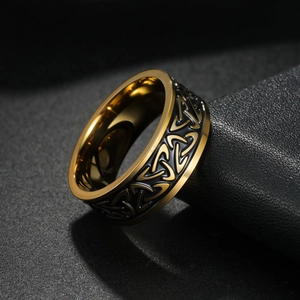 Macro detail of men's titanium ring with gold Celtic patterns on black band