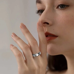 Macro detail of silver stainless steel ring with embossed dots and set zircons