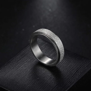 Close-up of silver spinner ring with glitter frosted finish on black leather box