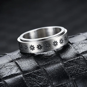 Detail of a rotating stainless steel daisy stress relief ring on black leather