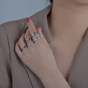 Set of four silver stainless steel rings with floral, frosted, and minimalist textures