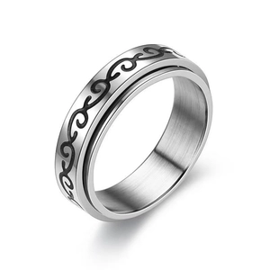 Detail of rotating stainless steel spinner ring with brushed finish and black vine pattern