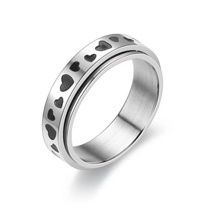 Detail showing brushed stainless steel texture and black heart pattern on rotating ring