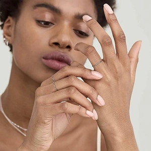 Close-up of minimalist 1mm silver polished stackable rings worn on a hand