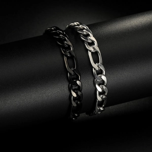 Bracciali a catena Figaro in acciaio al titanio lucidato nero e argento esposti su supporti