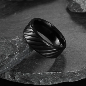 Men's minimalist black textured wedding band with diagonal grooves on dark stone
