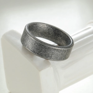 Bague vintage 7mm en acier inoxydable argenté vieilli sur socle en marbre blanc