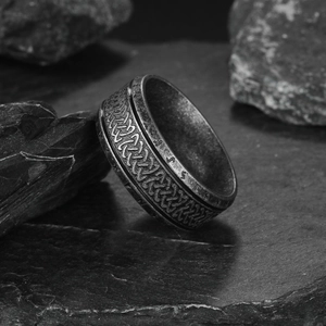 Vintage Viking stainless steel ring with Celtic knot and Nordic runes on dark rock