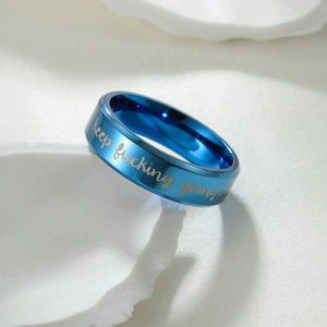 Bague en acier titane bleu poli avec citation de motivation gravée sur fond blanc