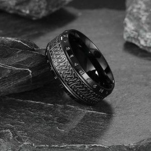Vintage Viking runes spinner ring in black stainless steel on dark slate rock