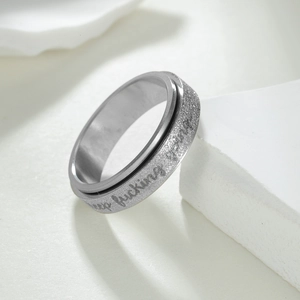 Macro shot of rotatable stainless steel ring with glitter finish and keep going engraving
