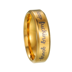 Détail macro d'une bague en acier doré avec gravure laser keep fucking going pour hommes