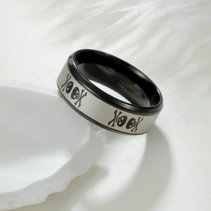 Vue macro d'une bague en acier brossé de 8 mm avec motifs tête de mort gravés au laser