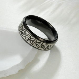 Détail d'une bague en acier noir de 8mm avec motif de vagues argentées gravé au laser