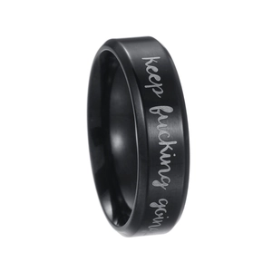 Détail d'une bague noire en acier titane brossé avec gravure Keep Fucking Going