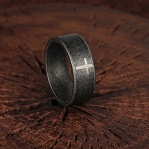 Anello vintage in acciaio con croce e finitura opaca su fondo in legno rustico