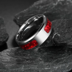 Silver steel ring with red opal inlay on black rock background in industrial style