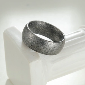 Retro brushed matte finish wide ring with textured surface for men on a white pedestal