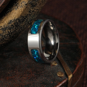 Macro shot of polished ring with vibrant blue opal inlay on a dark textured surface