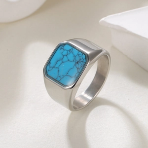 Men's vintage turquoise stainless steel wide ring on a minimalist white stone background