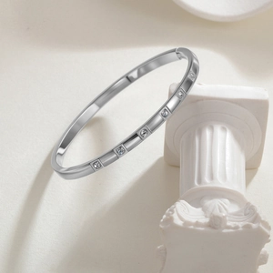 4MM silver stainless steel bangle with 6 cubic zirconia stones on a Roman column stand