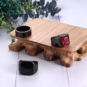 Three-piece black titanium ring set with a square red ruby inlay on vintage wood