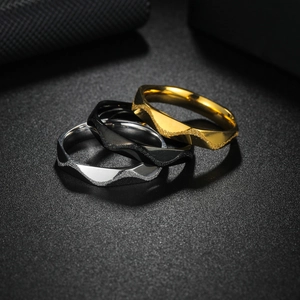 Detailed view of three-piece geometric titanium steel rings in gold, black, and silver
