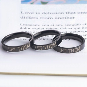 Three-piece black titanium ring set with Let Them engraved minimalist band style