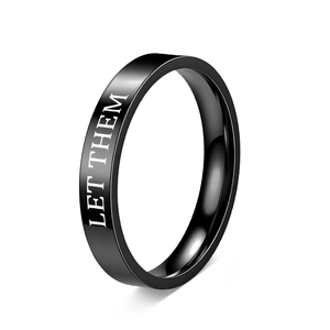 Detailed macro view of black polished titanium steel ring with white Let Them engraving