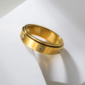 Bague rotative de luxe dorée sertie de diamants sur un présentoir moderne