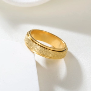 Detail of golden spinner ring with frosted glitter surface and polished steel edges