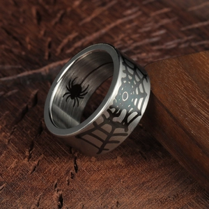 Gothic 10mm spider web titanium steel ring with internal spider carving on wood background