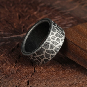 Bague industrielle de 10mm en acier titane à motif fissuré pour homme sur bois sombre