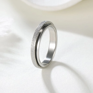 Macro detail of silver stainless steel spinner ring with matte finish and polished edge