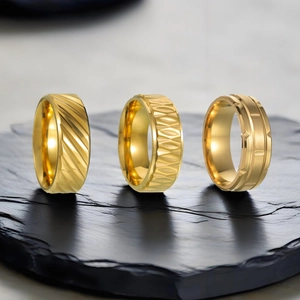Drei goldene Edelstahlringe für Herren mit geometrischen Mustern auf Steinsockel