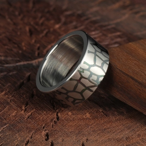 Bague homme 10mm en acier titane avec texture géométrique craquelée sur bois sombre